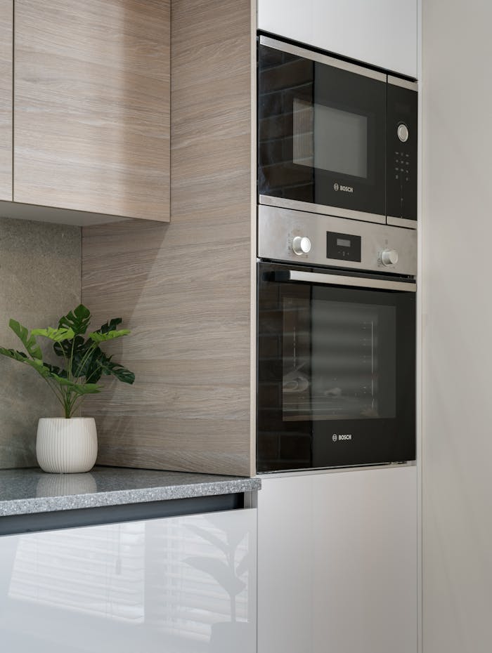 pexels photo 7614540 A sleek modern kitchen showcases built-in appliances with a chic plant accent on the countertop.